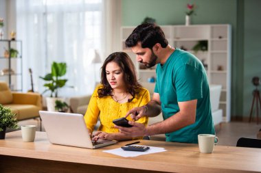 Mutlu genç Hintli evli çift masaya oturur giderleri hesaplar evde kolay internet bankacılığı hizmeti kullanır