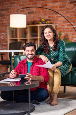 Mutlu genç Hintli evli çift masaya oturur giderleri hesaplar evde kolay internet bankacılığı hizmeti kullanır