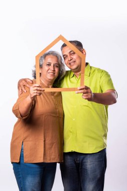 Hintli orta yaşlı gri saçlı çift ve beyaz arka planda emlak konsepti