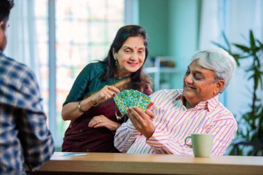 Hintli üst düzey bir çift evde iskambil oynamaktan hoşlanıyor.