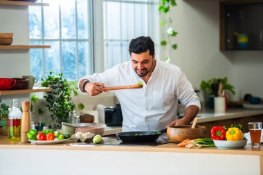 Hintli adam mutfakta tek başına yemek yapıyor.