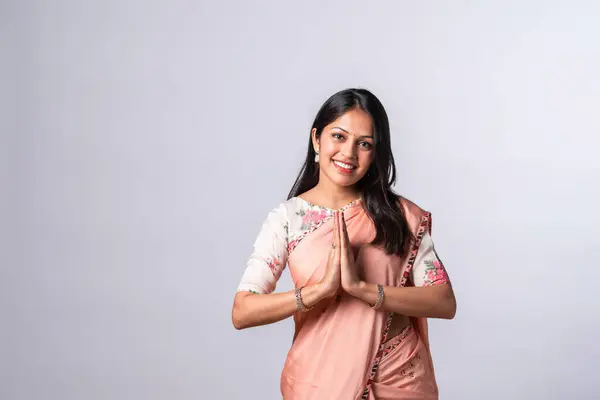 Indian asian young woman in welcome, namaskar or namaste pose in saree