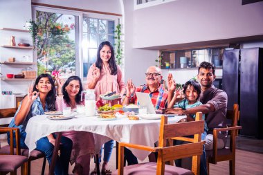 Mutlu Asyalı kuşak Hintli aile evde birlikte yemek yiyor..