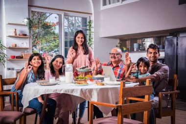 Mutlu Asyalı kuşak Hintli aile evde birlikte yemek yiyor..