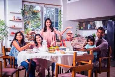 Mutlu Asyalı kuşak Hintli aile evde birlikte yemek yiyor..