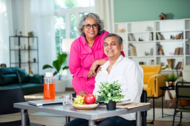 Mutlu, olgun bir Hintli son sınıf öğrencisi çift evde kahvaltı yapıyor..