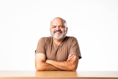 Yakışıklı Hintli emekli yaşlı bir adamın portresi beyaz duvara yaslanmış, farklı pozlar ve ifadelerle.