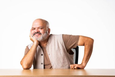 Yakışıklı Hintli emekli yaşlı bir adamın portresi beyaz duvara yaslanmış, farklı pozlar ve ifadelerle.