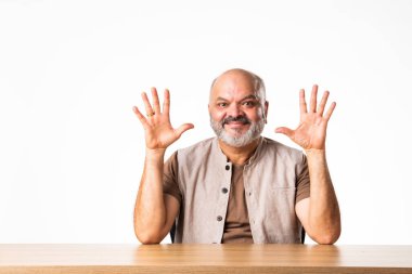 Hintli yakışıklı olgun yaşlı adam gülümseyen parmaklarına güveniyor.