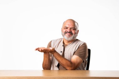 Yakışıklı Hintli emekli yaşlı bir adamın portresi beyaz duvara yaslanmış, farklı pozlar ve ifadelerle.