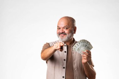 Beş yüz rupi banknot tutan mutlu Hintli adam beyaz arka planda yelpaze tutuyor.