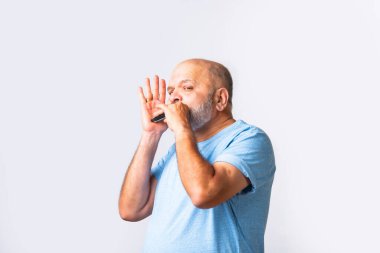 Yaşlı, yaşlı, Hintli, beyaz, mızıka ya da ağız organı çalan yaşlı bir adamın portresi.