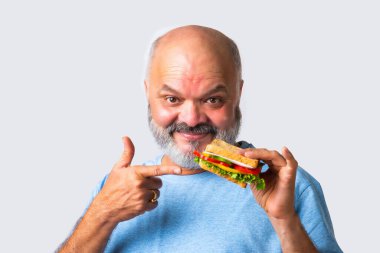 Asyalı yaşlı yaşlı adam lezzetli sebzeli sandviç yiyor, izole edilmiş.