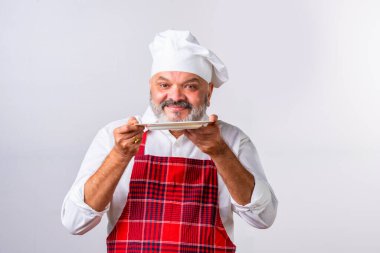 Yaşlı yaşlı yaşlı Hintli aşçı ya da profesyonel aşçı beyaz arka planda duruyor.