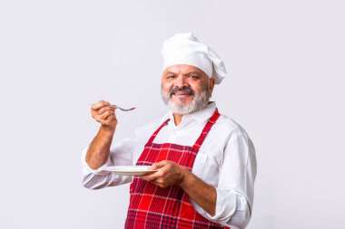Elderly senior old Indian asian male cook or professional chef standing against white background clipart