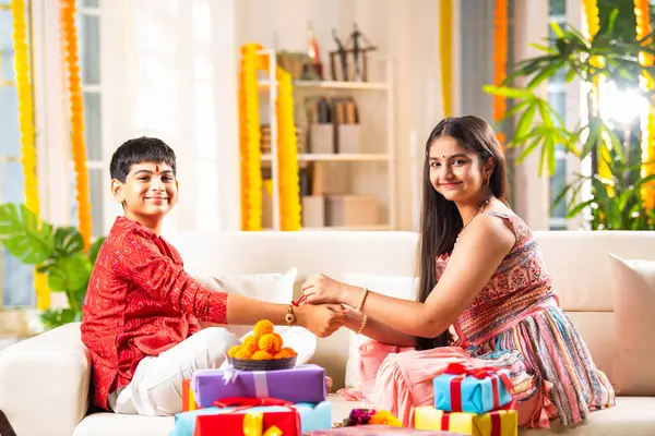 stock image Indian asian brothers and sisters celebrating rakhi festival, rakshabandhan or bhaidooj with sweets and gifts