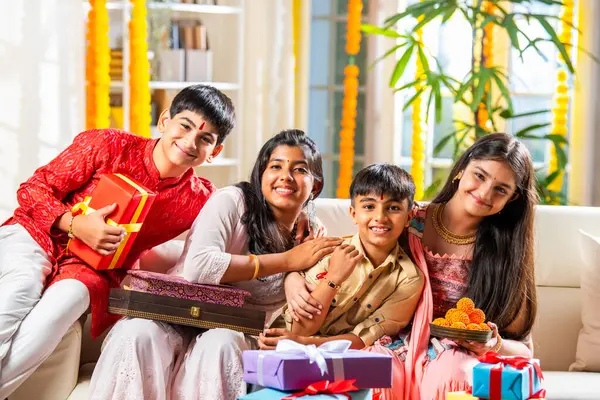 stock image Indian asian brothers and sisters celebrating rakhi festival, rakshabandhan or bhaidooj with sweets and gifts