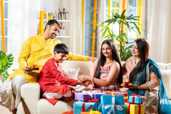 stock image Indian family celebrating rakhi, rakshabandhan or diwali celebration with gifts, sweet laddu, taking selfie