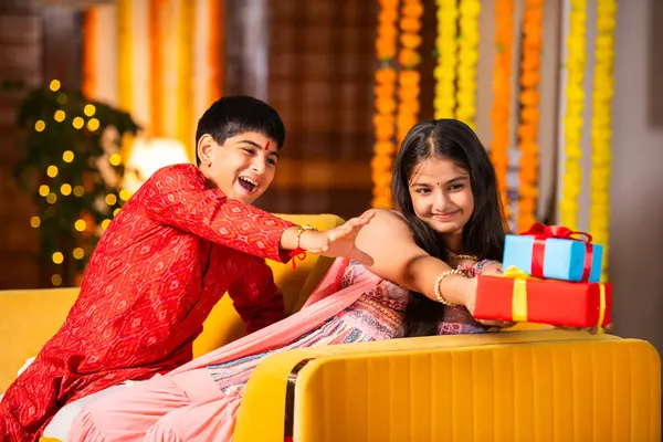 stock image Indian asian brothers and sisters celebrating rakhi festival, rakshabandhan or bhaidooj with sweets and gifts