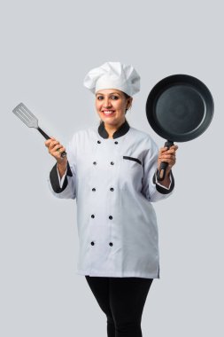 Kızartma tavası ve spatulası olan genç bayan aşçı. Profesyonel aşçı.