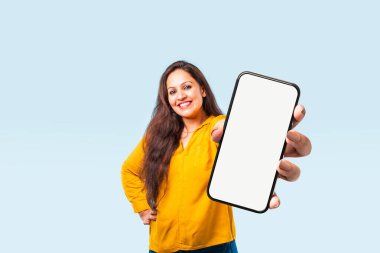 Hintli genç bir Asyalı kadın, modern teknolojiyi ön plana çıkaran boş bir ekranla akıllı telefon sergiliyor.