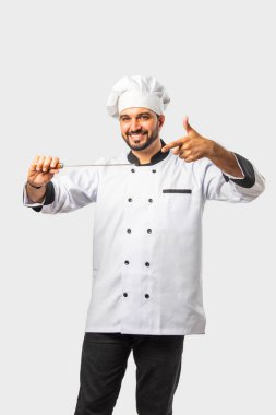 Indian asian young chef presenting paneer or chicken barbecue skewer clipart