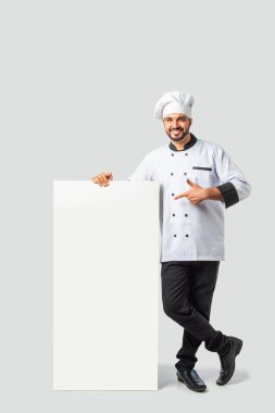 Genç Hintli Asyalı Üniformalı Erkek Şef Boş Tabela Tutuyor - Profesyonel Aşçı