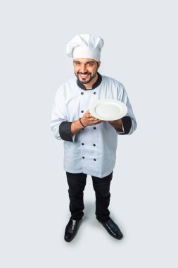 Hintli Asyalı aşçı ya da profesyonel aşçı. Terasotta pot handi, tabak ya da kase, yüksek açı manzaralı.