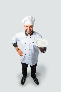 Hintli Asyalı aşçı ya da profesyonel aşçı. Terasotta pot handi, tabak ya da kase, yüksek açı manzaralı.