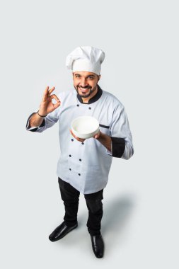 Hintli Asyalı aşçı ya da profesyonel aşçı. Terasotta pot handi, tabak ya da kase, yüksek açı manzaralı.