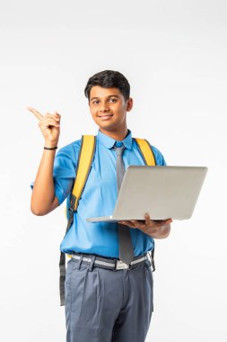 Hintli Asyalı okul çocuğu başparmak işareti yapıyor, başarıyı sunuyor veya kutluyor, izole edilmiş.