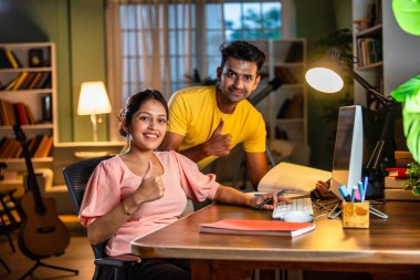 Genç Hintli Asyalı öğrenciler evde bilgisayar başında birlikte okuyorlar, çevrimiçi öğrenme ile uğraşıyorlar.