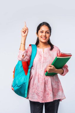 Sırt çantası, dizüstü bilgisayarı, işaret eden kitapları olan Asyalı genç kız.