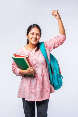 Sırt çantası, dizüstü bilgisayarı, işaret eden kitapları olan Asyalı genç kız.