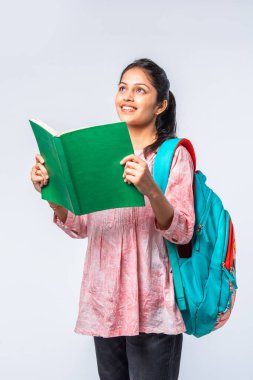 Sırt çantası, dizüstü bilgisayarı, işaret eden kitapları olan Asyalı genç kız.