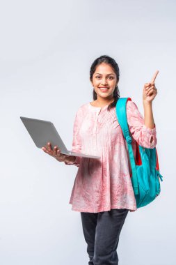 Sırt çantası, dizüstü bilgisayarı, işaret eden kitapları olan Asyalı genç kız.