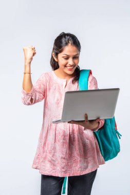 Sırt çantası, dizüstü bilgisayarı, işaret eden kitapları olan Asyalı genç kız.