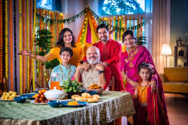 Mutlu Hintli Asyalı aile, Hindu festivalini kutluyor, yemek yiyor, evi süslüyor.