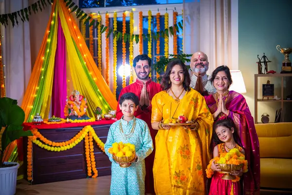 stock image Indian family in traditional wear performing Ganesh Puja or Aarti at home, a religious ritual