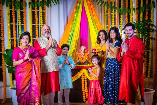 stock image Indian family in traditional wear performing Ganesh Puja or Aarti at home, a religious ritual