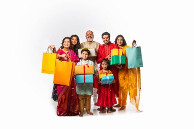 Çocukları ve büyükbabaları olan Hintli bir aile alışveriş torbaları ve Diwali ya da düğün hediyeleriyle hava atıyor.
