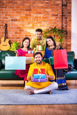 Mutlu Hintli çiftler ve geleneksel arkadaşlar Diwali 'yi evde içeceklerle, tatlılarla, hediyelerle, çiçeklerle, selfie çekerek ve birlikte eğlenerek kutlarlar..