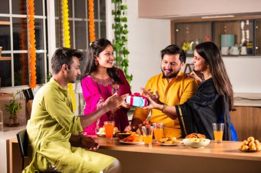Hint ailesi ve genç çift Diwali 'yi neşeli bir şekilde modern ev mutfağında kutluyor, bu canlı Hindu festivali sırasında masada lezzetli yemekler, kahkahalar ve hikayeler paylaşıyorlar.