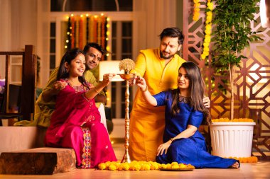 Hint Asyalı genç çiftler ya da Diwali 'de samai ya da diya yakan arkadaşları, Işık Festivali' ni canlı kültürel geleneklerle birlikte kutluyorlar.