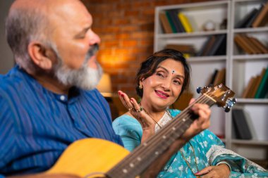 Emekli bir Hintli çift, kocası gitarı çalarken karısı neşeyle yakın planda sevdiği bir şarkıyı söylerken yürekten bir anı paylaşır.