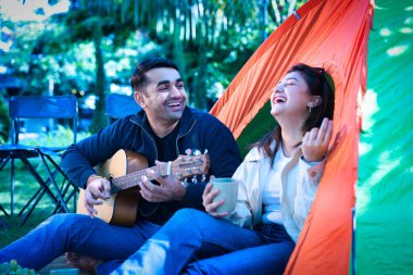 Hintli, Asyalı genç bir çift ya da kamp gezisinin tadını çıkaran arkadaşlar, kahve yudumlayan, kitap okuyan ya da gitar çalan. Gülüyorlar ve açık havada eğlenceli anları paylaşıyorlar, hatıralar yaratıyorlar.