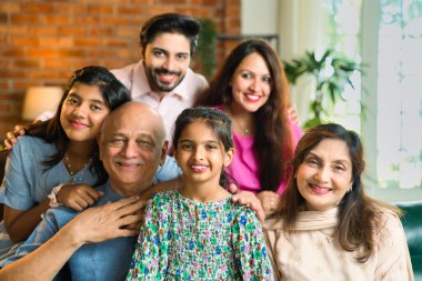 Hintli Asyalı, altı nesilden oluşan çok yönlü bir ailenin, lüks bir evde, bir kanepede birlikte oturması, mutlu anları paylaşması ve nesiller boyu bağ kurması.