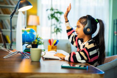 İnce İndian Asya İlköğretim Okulu öğrencisi Kız Evde Bilgisayar Kullanarak Sanal Online Sınıfa Katılıyor, Öğretmenle Öğreniyor ve İletişim Kuruyor, Modern Eğitim, E-Öğrenme ve Teknolojiyi Vurguluyor