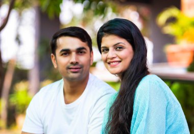 Hintli, güzel, mutlu, genç bir çift verandada oturuyor. Etrafı yeşilliklerle çevrili. Birlikte sabah kahvesinin tadını çıkarıyorlar.