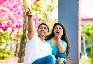 Hintli, güzel, mutlu, genç bir çift verandada oturuyor. Etrafı yeşilliklerle çevrili. Birlikte sabah kahvesinin tadını çıkarıyorlar.